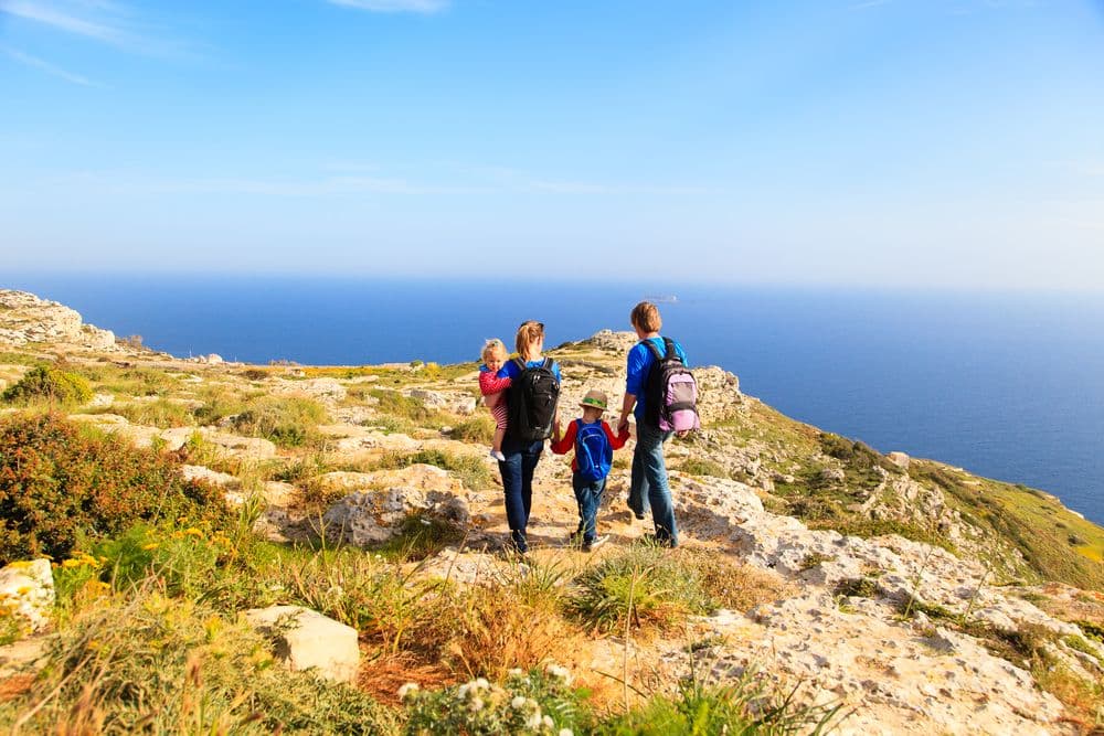 A family hiking on a mountain with ocean view.