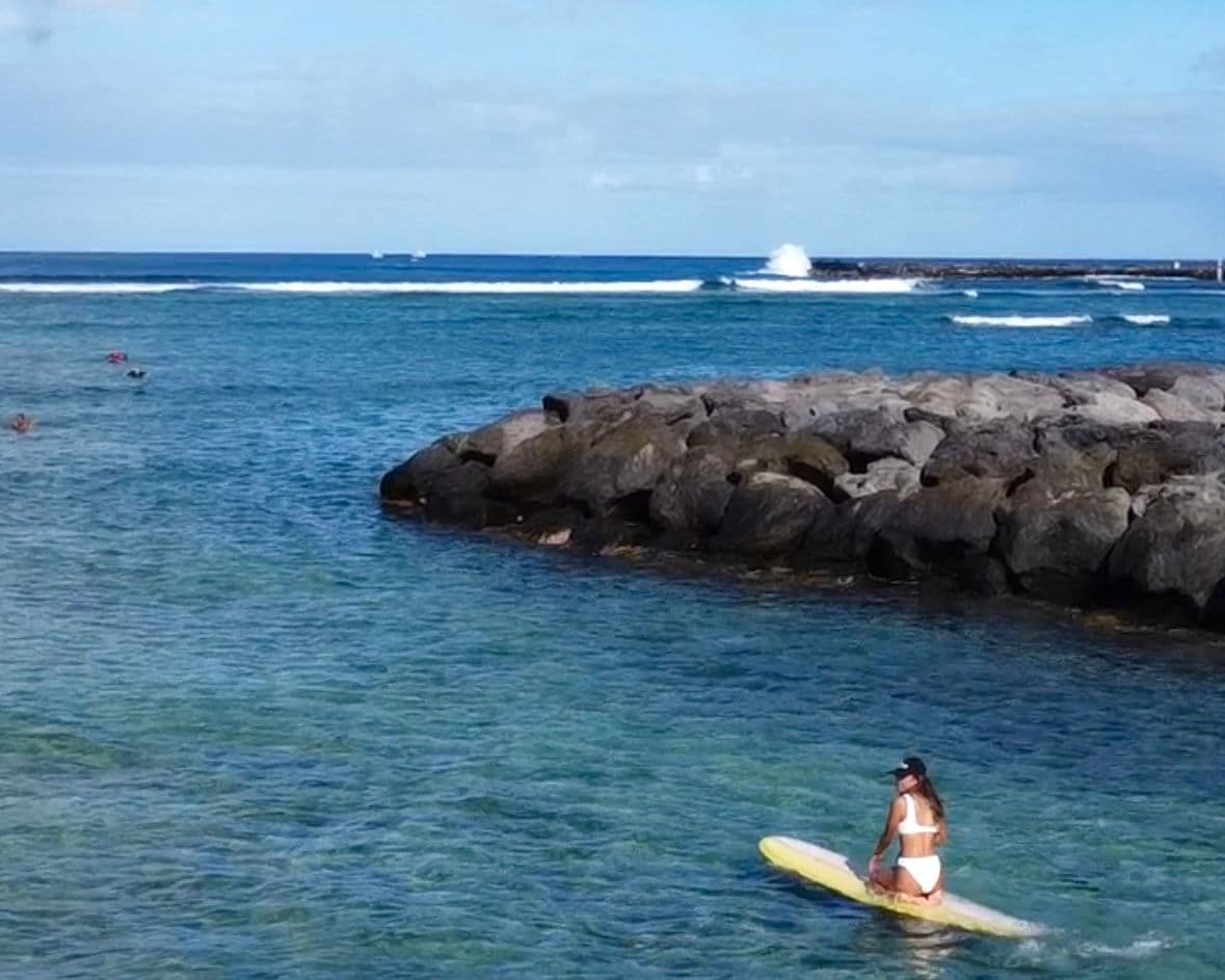 Woman on surfboard in the ocean in hawaii.
