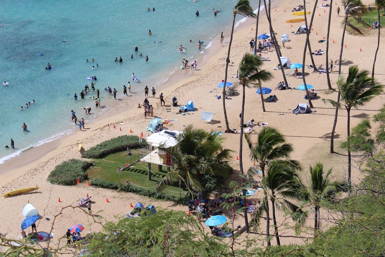 Crowded beach, lifeguard stand, palm trees