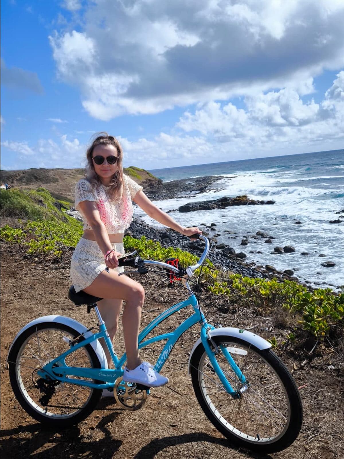 woman on bike in front of ocean at the beach