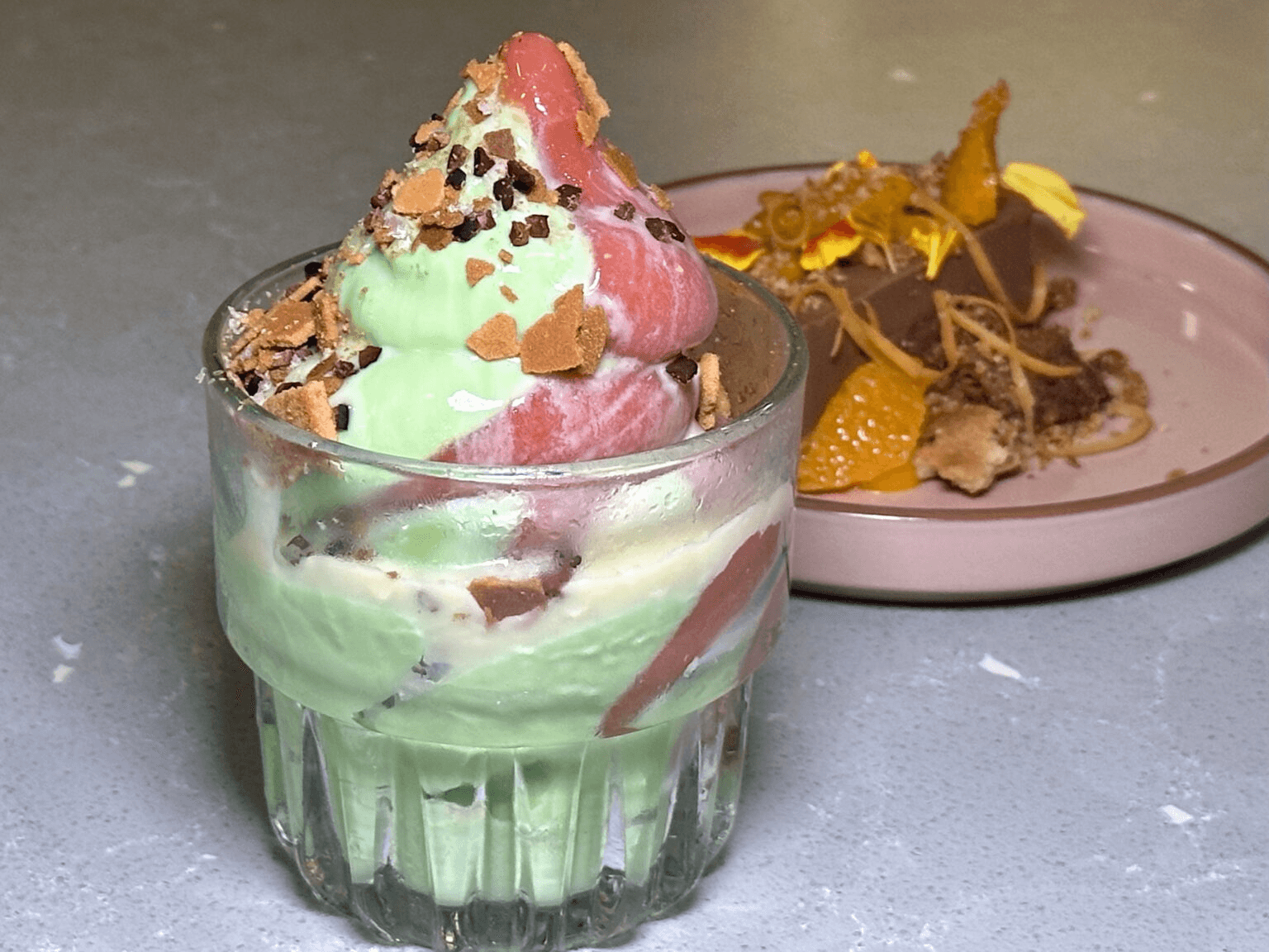 Save room for dessert. The current soft serve swirl (front) is avocado-matcha custard and strawberry guava sorbet, coated in crushed feuilletine (think Frosted Flakes) wafer and salted condensed milk. Another must-try is the Dark Chocolate Crémeux (back). Photo by Sarah Burchard.