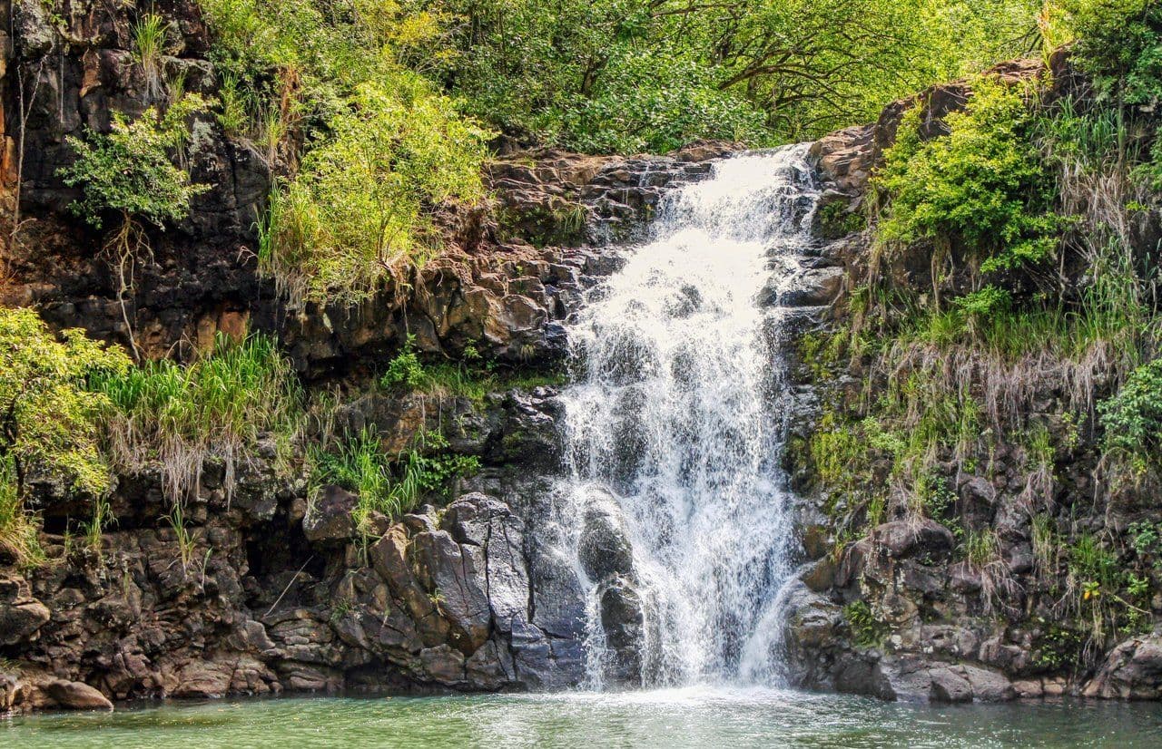 waterfall with lush green mountains