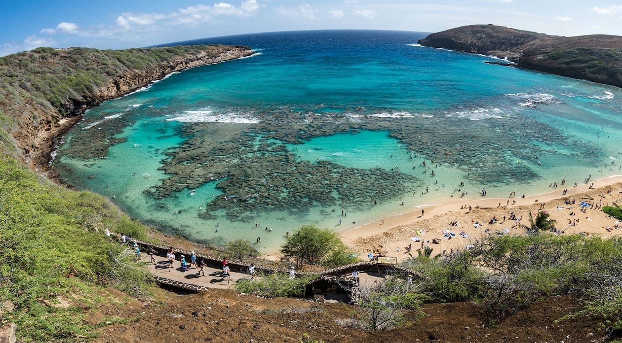 crescent shaped bay with turquoise water in a volcanic tuff cone