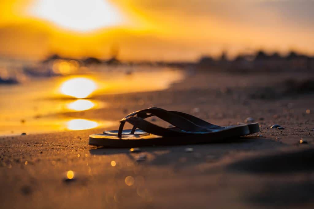 A slipper on a beach.