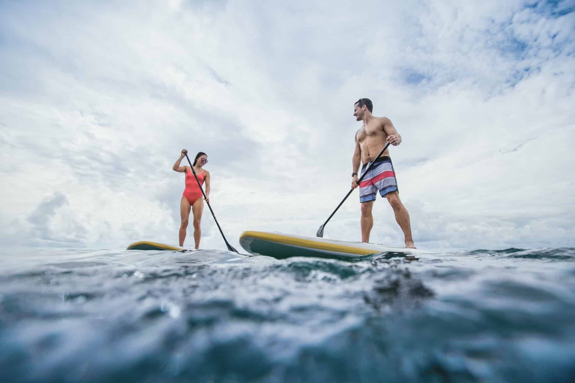 man and a woman on standup paddle boards