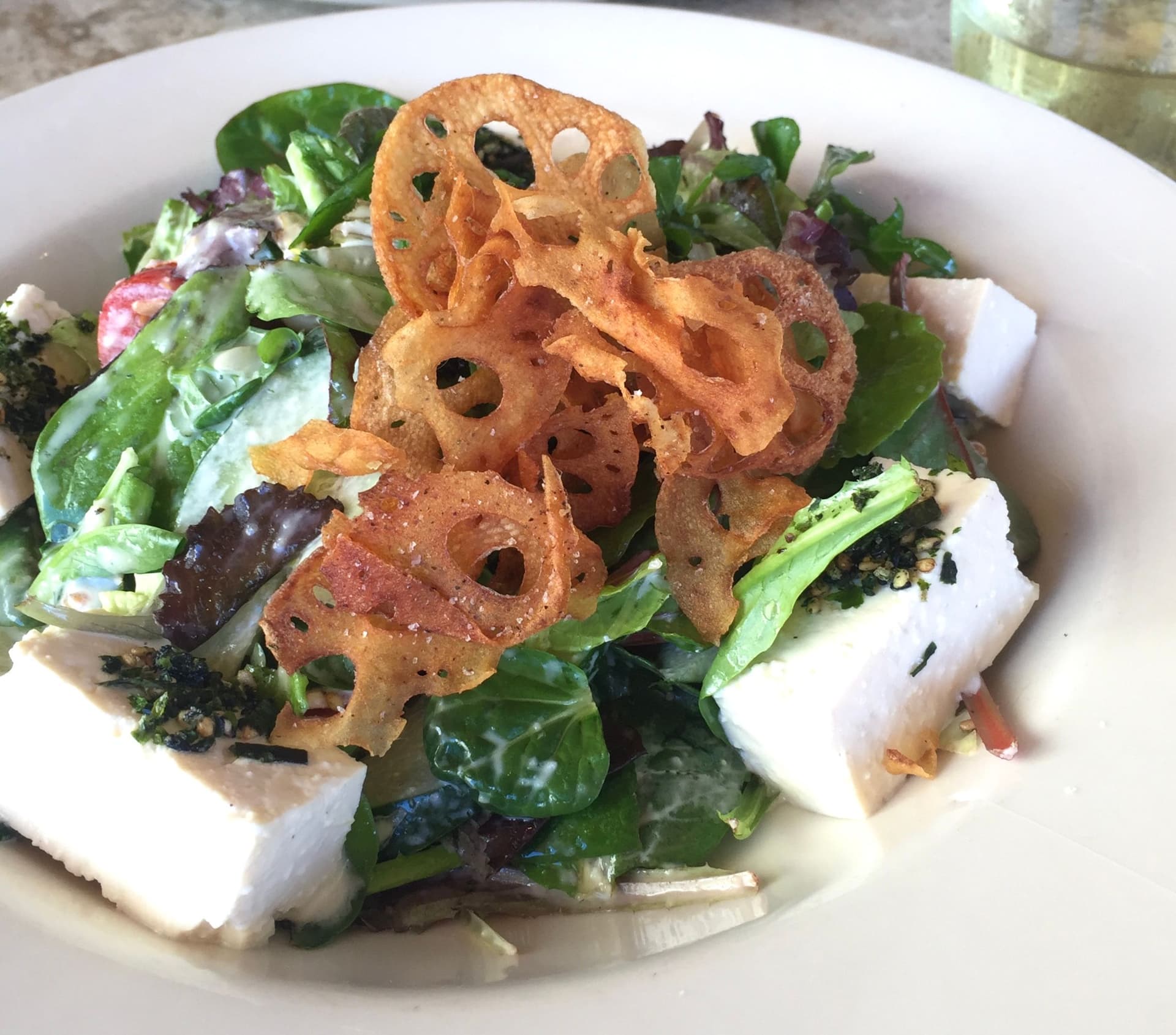 A tofu salad with fried lotus root, spinach and seaweed.