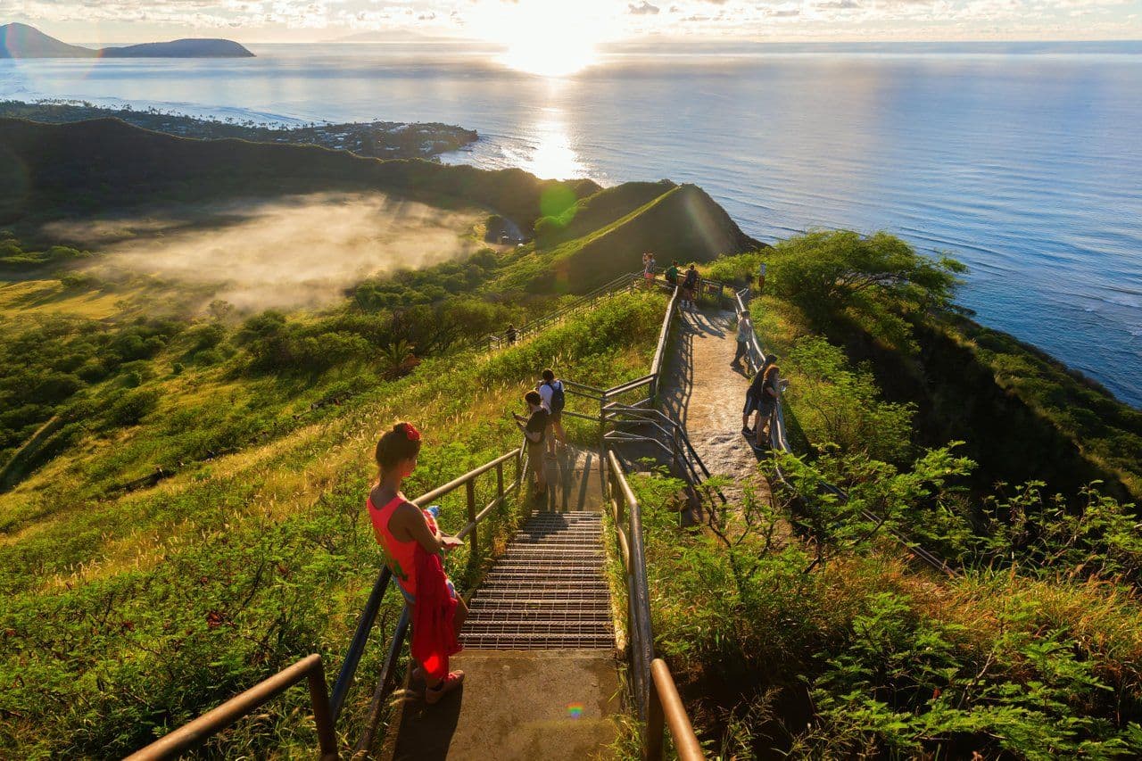 A long stairway down a mountain to the ocean with hikers on it.