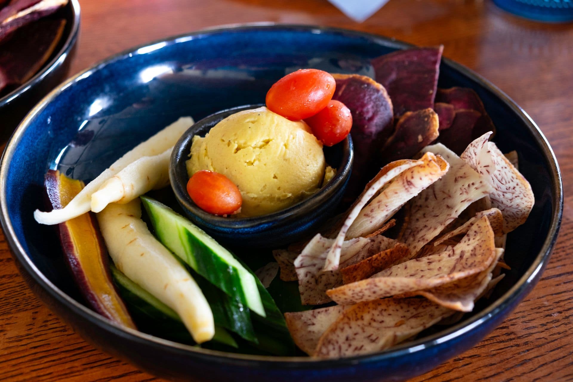 ulu hummus with cherry tomatoes, taro chips, cucumber slices and carrots