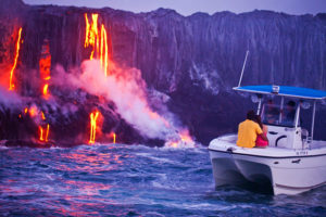 Couple watches lava flowing into the sea. Photo courtesy of Hawaii Tourism Authority (HTA) / Tor Johnson.