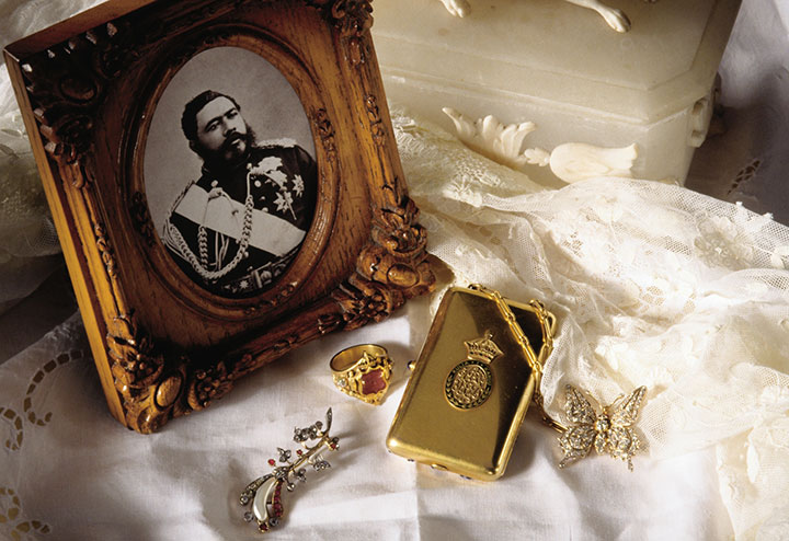 King Kalakaua was the last reigning King of the Hawaiian Kingdom.  Show here is a photo of His Majesty King Kalakaua, his ring, and pieces of jewelry belonging to his wife, Queen Kapiolani, including her diamond broach, compact, and diamond butterfly pin with wings that will flutter gently when moved.  (Hawaii Visitors and Convention Bureau (HVCB)/Linda Ching)