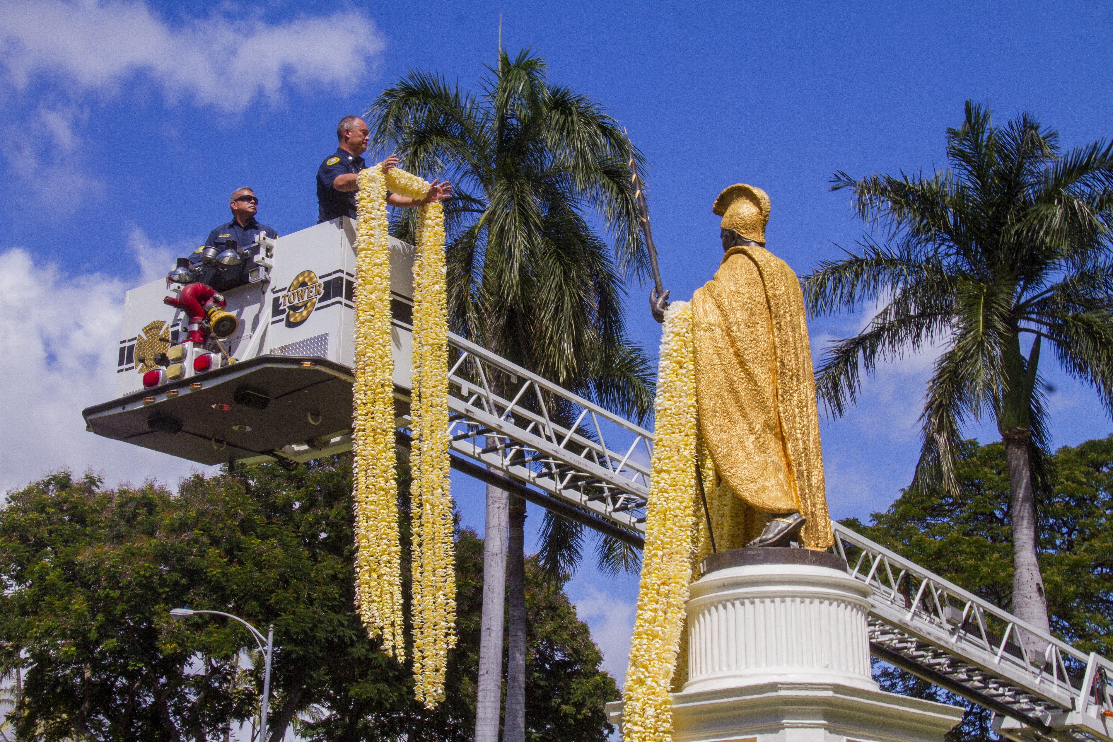 Workers drape lei on the King Kamehameha statue in Honolulu